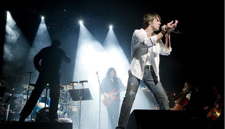 Image of man on stage singing on the mic