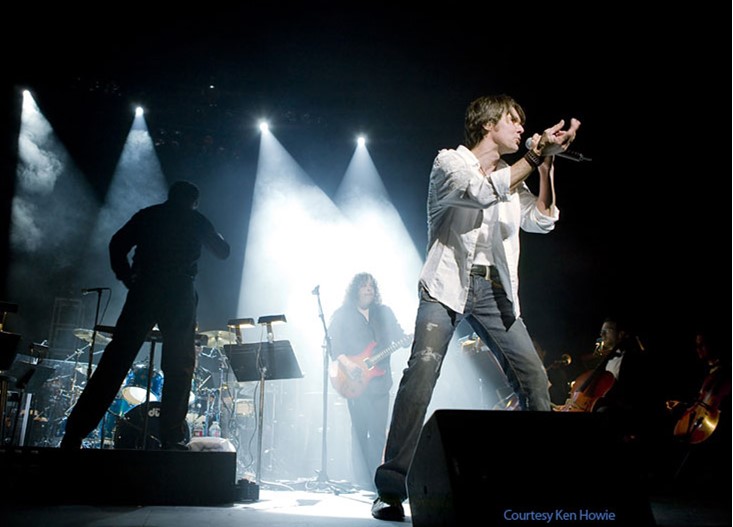 Image of man on stage singing on the mic
